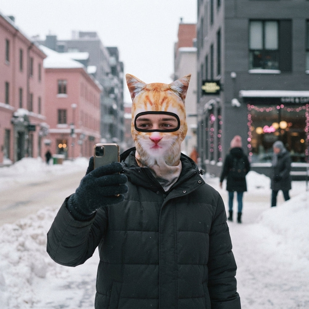 A person wearing a hyper-realistic 3D cat face balaclava mask while standing on a snowy city street.